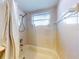 Bright bathroom featuring tiled walls, a shower/tub combo with curtain, and a window for natural light at 6353 River Rd, New Smyrna Beach, FL 32169
