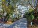 Charming home with a gray garage door, and a driveway lined with plants and trees at 6353 River Rd, New Smyrna Beach, FL 32169