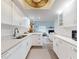 Open-concept kitchen with white cabinets, speckled countertops, and view into the living area at 6353 River Rd, New Smyrna Beach, FL 32169