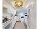 Bright, updated kitchen with white cabinets, speckled countertops, and open view to the living room at 6353 River Rd, New Smyrna Beach, FL 32169