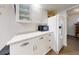 Bright kitchen features white cabinets, stainless steel microwave and refrigerator, and speckled countertop at 6353 River Rd, New Smyrna Beach, FL 32169