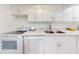 Well-lit kitchen showcases white cabinets, speckled countertops, and updated appliances at 6353 River Rd, New Smyrna Beach, FL 32169