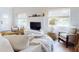 Bright and airy living room featuring a white brick fireplace, comfortable seating, and natural light at 6353 River Rd, New Smyrna Beach, FL 32169
