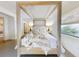 Spacious main bedroom with four-poster bed, and large window showcasing an outside view at 6353 River Rd, New Smyrna Beach, FL 32169