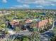 Stunning aerial view of the clubhouse, featuring a tile roof, palm trees and lush landscaping at 7833 Oak Reflection Loop, Davenport, FL 33837