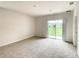 Spacious bedroom with neutral walls, carpet, and sliding glass doors to a patio at 791 Chinoy Rd, Davenport, FL 33837