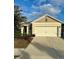 Charming single-story home featuring a tan stucco exterior, two-car garage, and well-maintained landscaping at 791 Chinoy Rd, Davenport, FL 33837