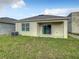Tan house exterior with sliding glass doors to patio at 791 Chinoy Rd, Davenport, FL 33837