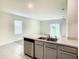 Kitchen with gray cabinets, stainless steel appliances and a view of the living room at 791 Chinoy Rd, Davenport, FL 33837