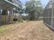 Large backyard featuring a wooden fence, a metal carport and a screened in enclosure at 1625 Normandy Way, Leesburg, FL 34748