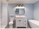 Bathroom featuring a white vanity, a blue shiplap wall, a soaking tub, and glass shower at 2260 Mulbry Dr, Winter Park, FL 32789