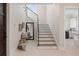 Entryway with stairs, modern railing, bench, and a view into the laundry room at 2260 Mulbry Dr, Winter Park, FL 32789
