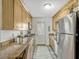 Kitchen showcasing wood cabinets, granite countertops, and stainless steel refrigerator at 320 Lakeview St # 123, Orlando, FL 32804