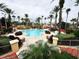 Relaxing community pool surrounded by palm trees and lounge chairs at 3602 Calabria Ave, Davenport, FL 33897