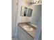 A bathroom featuring a single sink vanity, a large mirror, and standard lighting at 5542 Metrowest Blvd # 206, Orlando, FL 32811