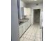 Bright kitchen with white appliances, cabinetry, and tile flooring at 5542 Metrowest Blvd # 206, Orlando, FL 32811