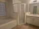 Main bathroom with a tub, shower and updated vanity at 713 Swan Way, Kissimmee, FL 34758