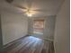 Bright bedroom with wood-look floors, a ceiling fan, and a window with wood blinds at 713 Swan Way, Kissimmee, FL 34758