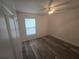 Well-lit bedroom featuring wood-look floors, a ceiling fan, and a window with blinds at 713 Swan Way, Kissimmee, FL 34758