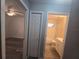 Hallway view of the bathroom and bedroom with wood-look floors, neutral paint, and a closet at 713 Swan Way, Kissimmee, FL 34758