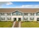Two-story townhouses with gray siding, brown roofs and grassy yards at 826 Paradise Dr, Davenport, FL 33897
