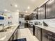 Modern kitchen with dark cabinets, granite countertops, and stainless steel appliances at 826 Paradise Dr, Davenport, FL 33897