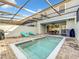 Screened-in backyard pool featuring lounge chairs, a dining table, and brick pavers at 826 Paradise Dr, Davenport, FL 33897