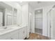 Bathroom featuring double vanity, mirrors, and a glass-enclosed shower at 1124 Griffon Ave, Lake Alfred, FL 33850