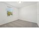 Carpeted bedroom with window featuring tree and blue sky views at 1124 Griffon Ave, Lake Alfred, FL 33850