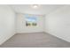 Bedroom with neutral carpet, large window, and plenty of natural light at 1124 Griffon Ave, Lake Alfred, FL 33850