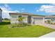 Single-story home boasting a two-car garage, well-kept lawn, and tasteful landscaping at 1124 Griffon Ave, Lake Alfred, FL 33850
