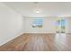Spacious living room with sleek wood-look floors, a large window, and sliding glass doors to the patio at 1124 Griffon Ave, Lake Alfred, FL 33850