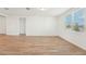 Bright, open living room with wood-look tile floors, large window, and neutral walls at 1124 Griffon Ave, Lake Alfred, FL 33850