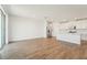 Bright, open living room featuring wood-look flooring, stainless steel appliances, and access to a covered lanai at 1124 Griffon Ave, Lake Alfred, FL 33850