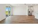 Bright and airy living room with wood-look tile flooring, a sliding glass door, and stainless steel refrigerator at 1124 Griffon Ave, Lake Alfred, FL 33850
