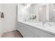 Sleek bathroom features double sink vanity, modern lighting, decorative mirror, and neutral decor at 12608 Ne 49Th Dr, Oxford, FL 34484