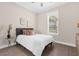 Cozy bedroom with natural light, a comfortable bed, and minimalistic decor for a serene atmosphere at 12608 Ne 49Th Dr, Oxford, FL 34484