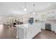 Bright kitchen features large island with bar seating, stainless appliances, and open layout to dining and living area at 12608 Ne 49Th Dr, Oxford, FL 34484