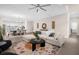 Cozy living room with plush seating, accent rugs, and decor, flowing into dining and kitchen areas at 12608 Ne 49Th Dr, Oxford, FL 34484