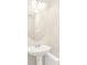 Bathroom featuring a white pedestal sink, oval mirror and modern chrome fixtures at 14480 Chinese Elm Dr, Orlando, FL 32828
