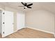 Neutral bedroom with a ceiling fan, wood flooring, and a double door closet at 14480 Chinese Elm Dr, Orlando, FL 32828