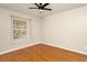Bright bedroom featuring hardwood floors, a ceiling fan, and a large window at 14480 Chinese Elm Dr, Orlando, FL 32828