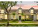 Charming townhouse with lush landscaping, green lawn, and inviting front entrance at 14480 Chinese Elm Dr, Orlando, FL 32828