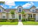 Charming townhome featuring well-maintained landscaping and a welcoming teal front door at 14480 Chinese Elm Dr, Orlando, FL 32828