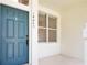 Inviting front porch featuring a teal door and a window, creating a warm entry at 14480 Chinese Elm Dr, Orlando, FL 32828