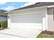 Spacious two-car garage with white door and clean concrete driveway at 14480 Chinese Elm Dr, Orlando, FL 32828