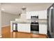 Modern kitchen featuring stainless steel appliances, white cabinets, and hardwood floors at 14480 Chinese Elm Dr, Orlando, FL 32828