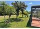 Lush backyard landscape design with mature trees near a screened-in patio at 2355 Abalone Blvd, Orlando, FL 32833