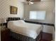Bright bedroom with patterned wallpaper, featuring a covered bed, bedside table, and a window at 2355 Abalone Blvd, Orlando, FL 32833