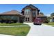 Two-story brick house with a brown roof, attached garage, and a long driveway at 2355 Abalone Blvd, Orlando, FL 32833